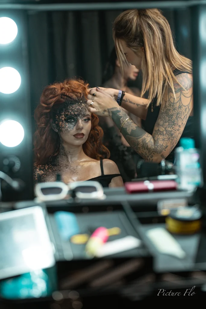 Coiffeuse aux bras tatoués sur la chevelure rousse de Marine, coulisses de la Lux Fashion Week 2026, Arlon