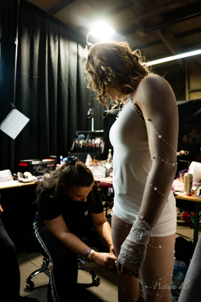 Derniers réglages sur un body blanc perlé et des gants de dentelle, coulisses de la Lux Fashion Week 2026, Arlon