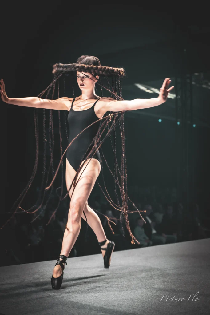 Léa, bras ouverts, en justaucorps noir et pointes sur le podium, Lux Fashion Week 2026, Arlon