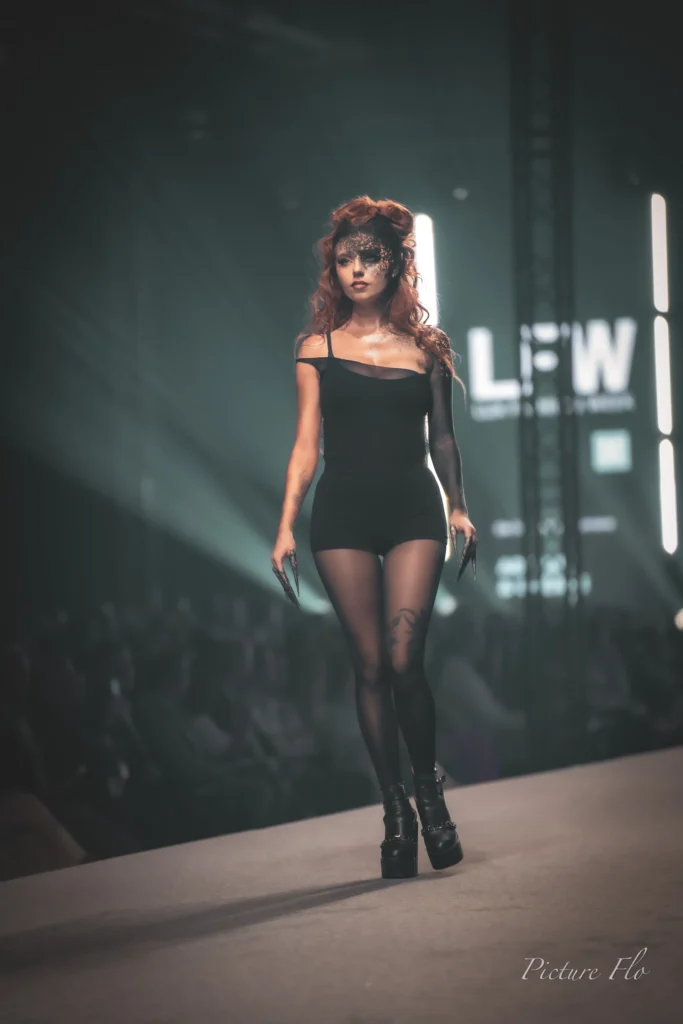 Marine sur le podium, chevelure rousse et masque noir et bronze, Lux Fashion Week 2026, Arlon