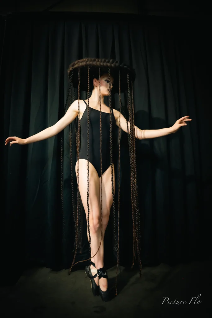 Léa bras ouverts sous le chapeau de tresses, portrait en studio, Lux Fashion Week 2026, Arlon