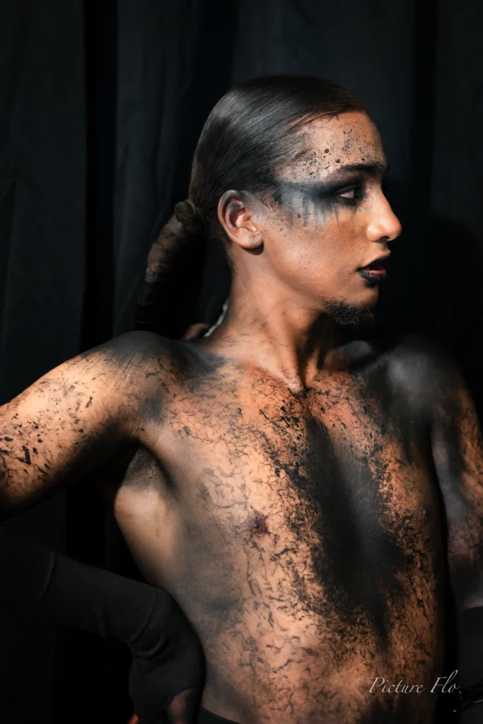 Youness de profil, torse maquillé de noir craquelé, portrait en studio, Lux Fashion Week 2026, Arlon