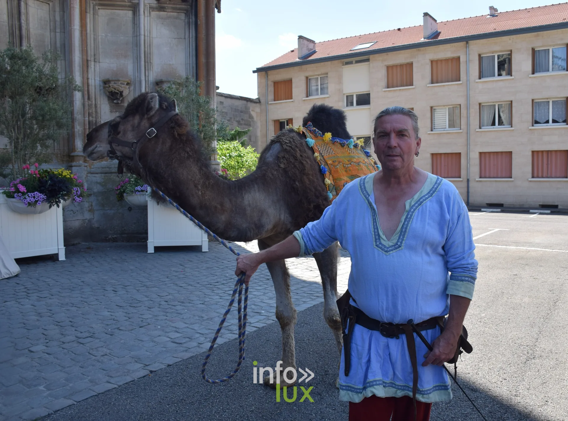 Homme en costume tenant un chameau lors d'une animation de rue