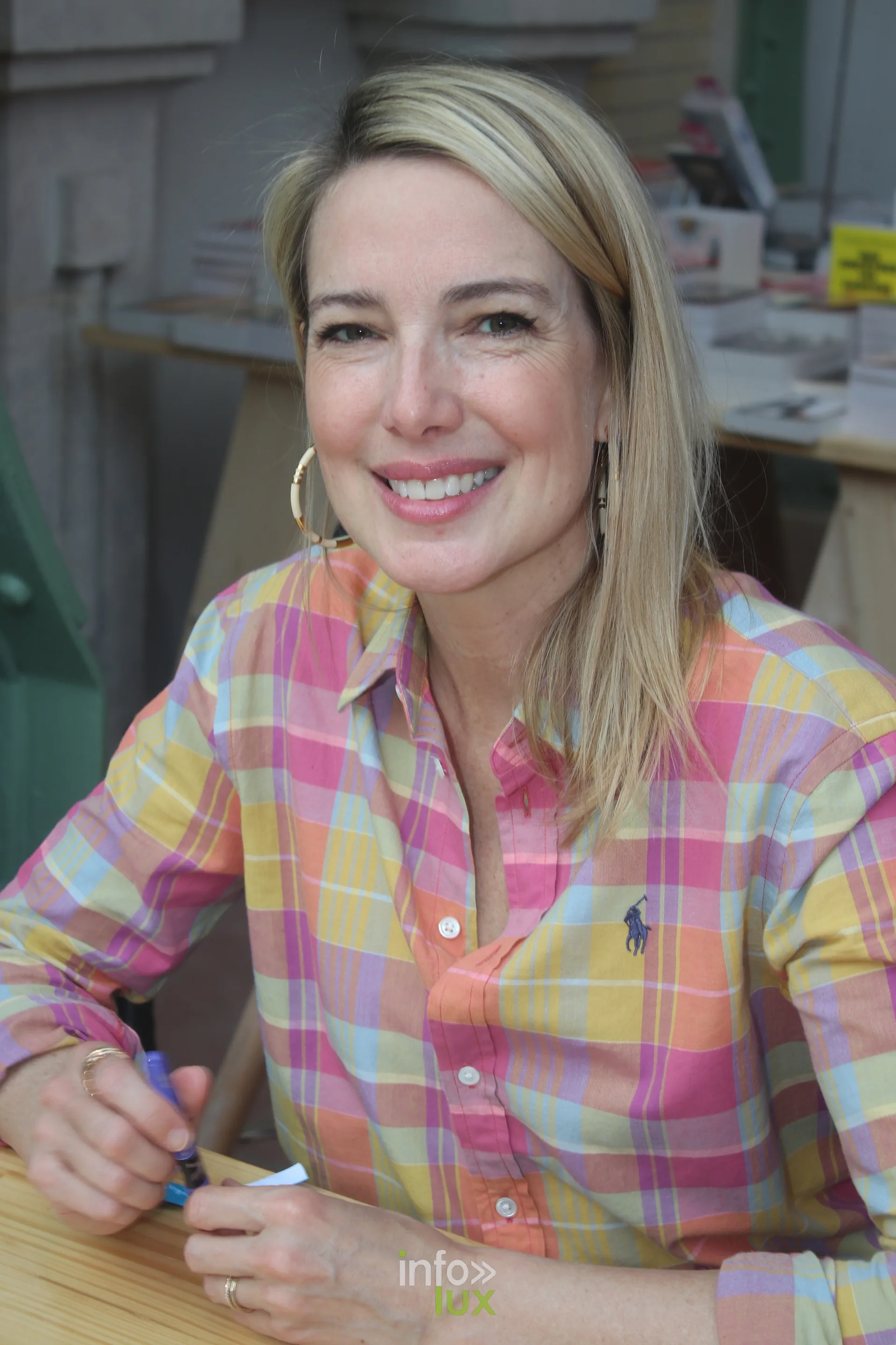 Autrice souriante en chemise a carreaux au Festival du Livre de Paris