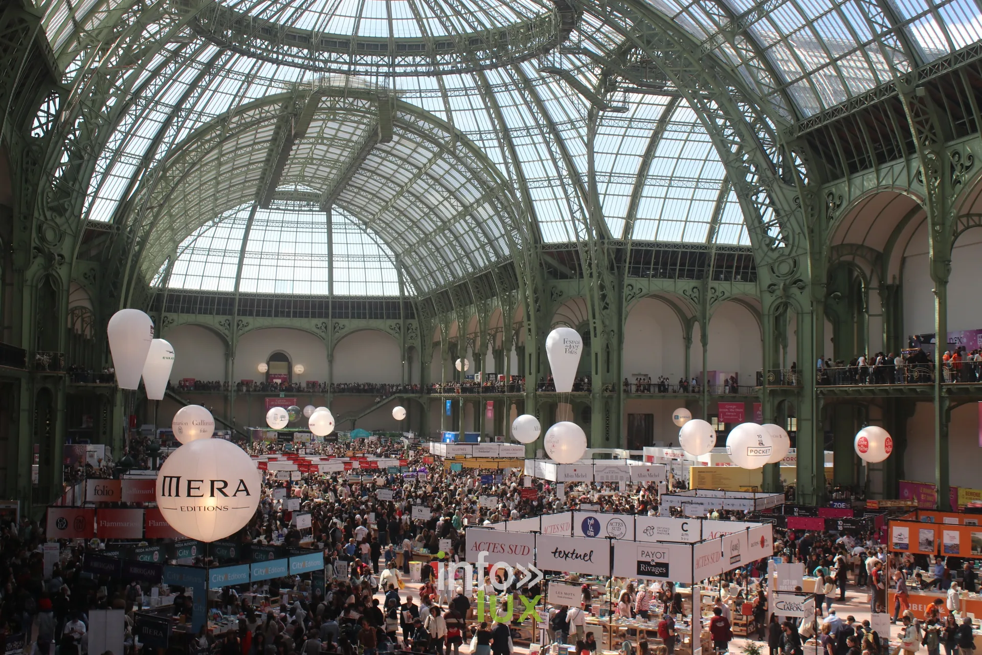 Vue en hauteur de la nef du Grand Palais remplie de visiteurs pendant le Festival du Livre de Paris