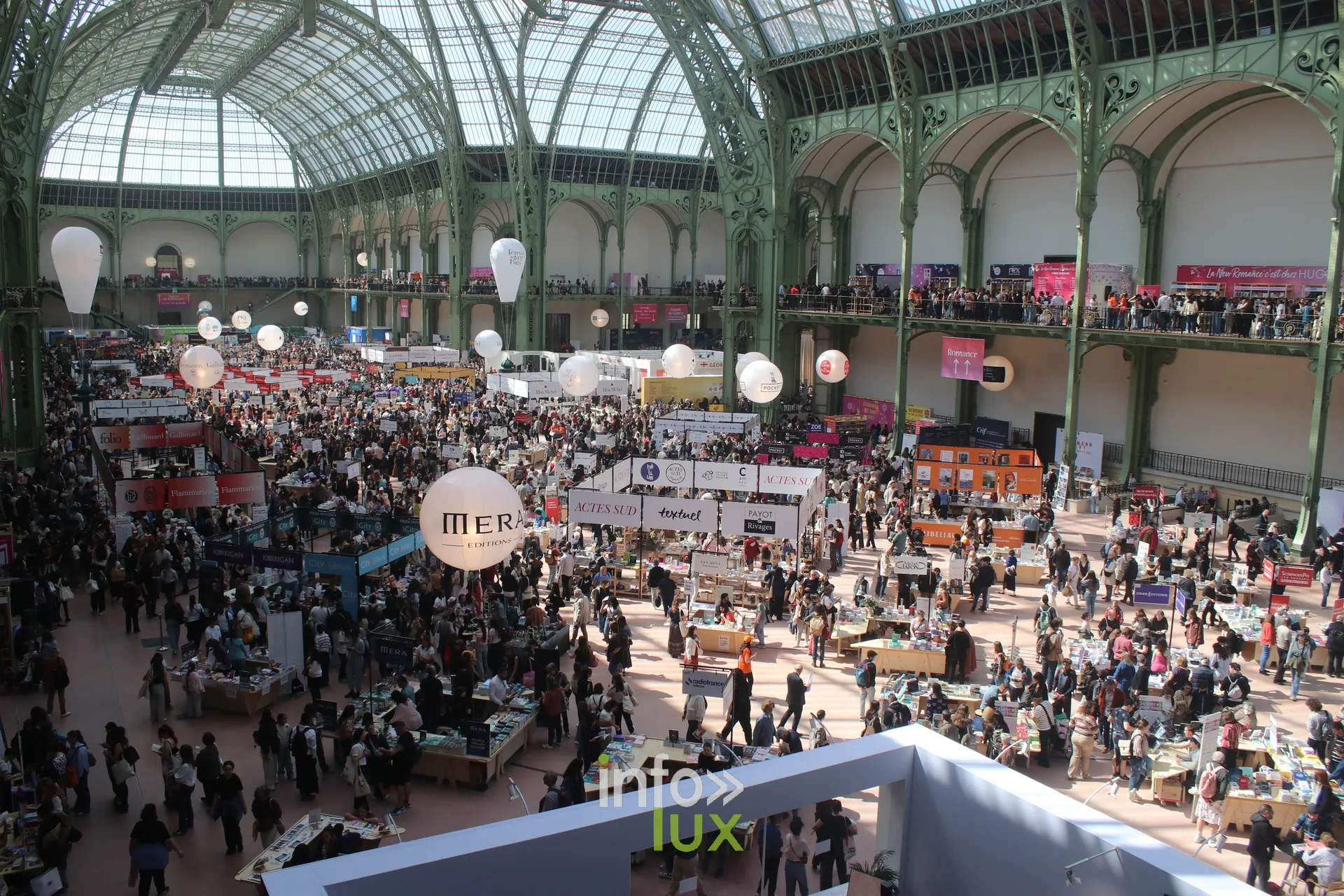 Stands d'editeurs et foule sous la verriere du Grand Palais a Paris