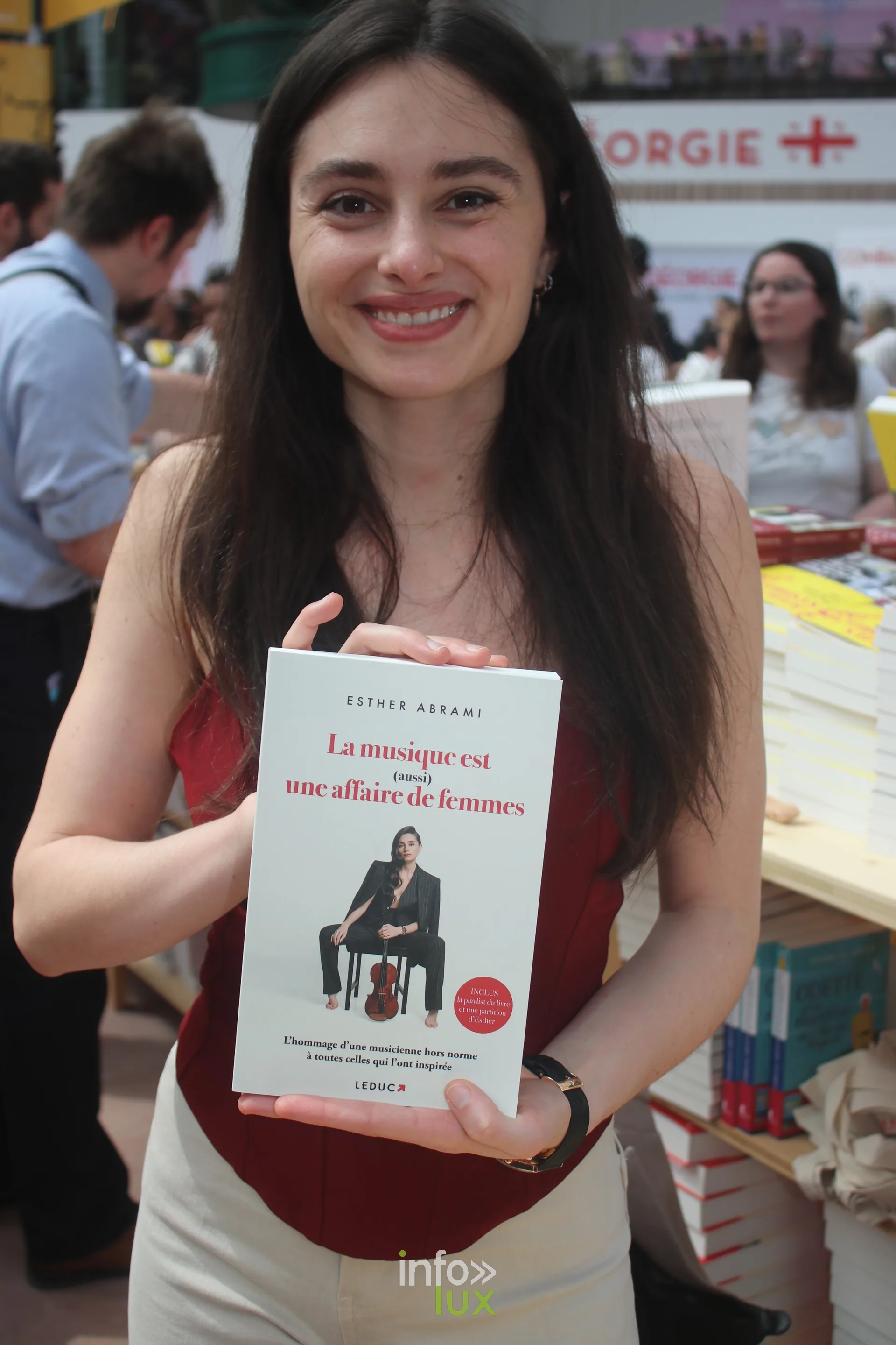 Jeune autrice souriante tenant son livre au Festival du Livre de Paris