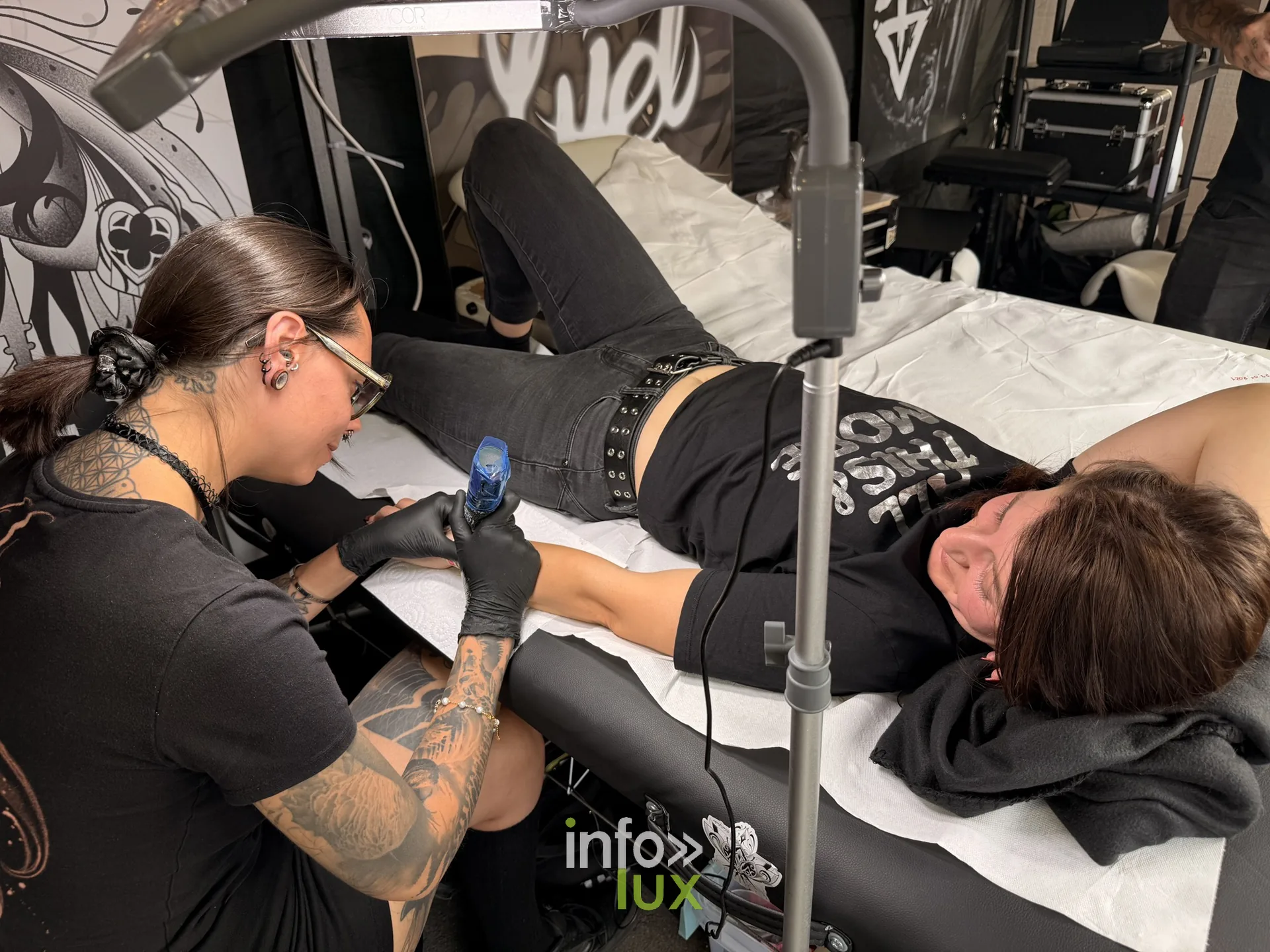 Une tatoueuse au travail au village de l'Amné'stival