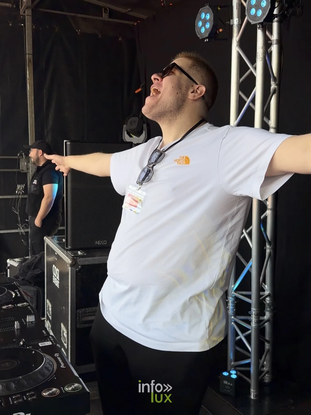 Un DJ bras grands ouverts sur la scène de l'Amné'stival