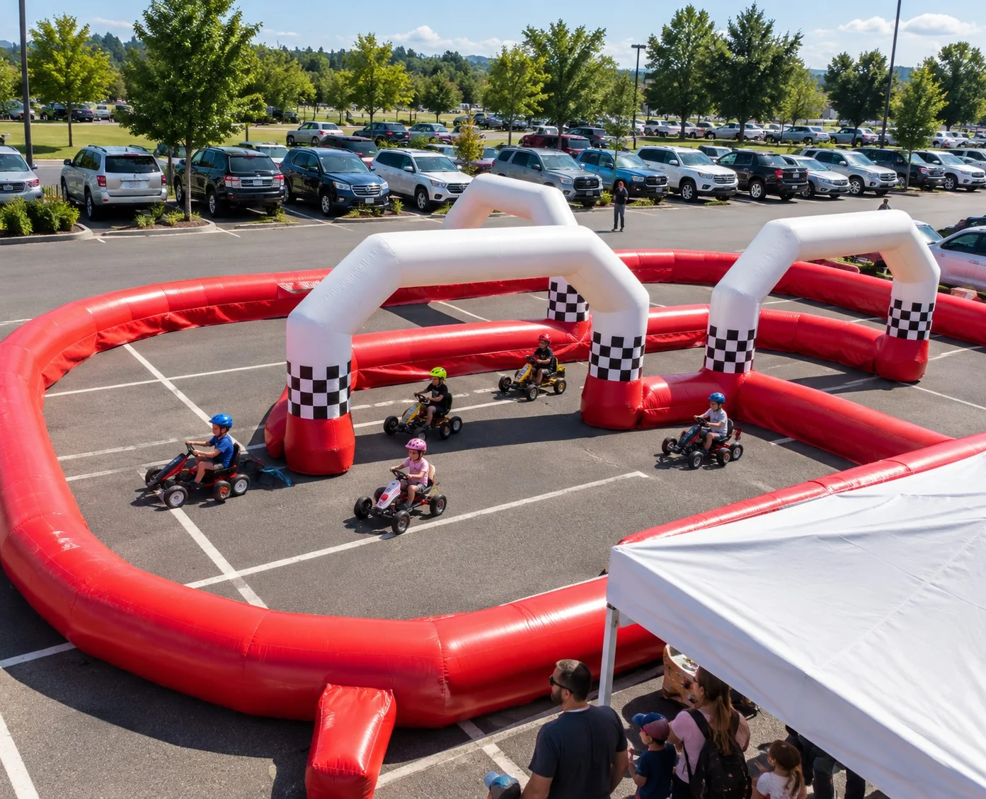 Circuit de go-karts gonflable rouge et blanc installé sur un parking, vu de haut