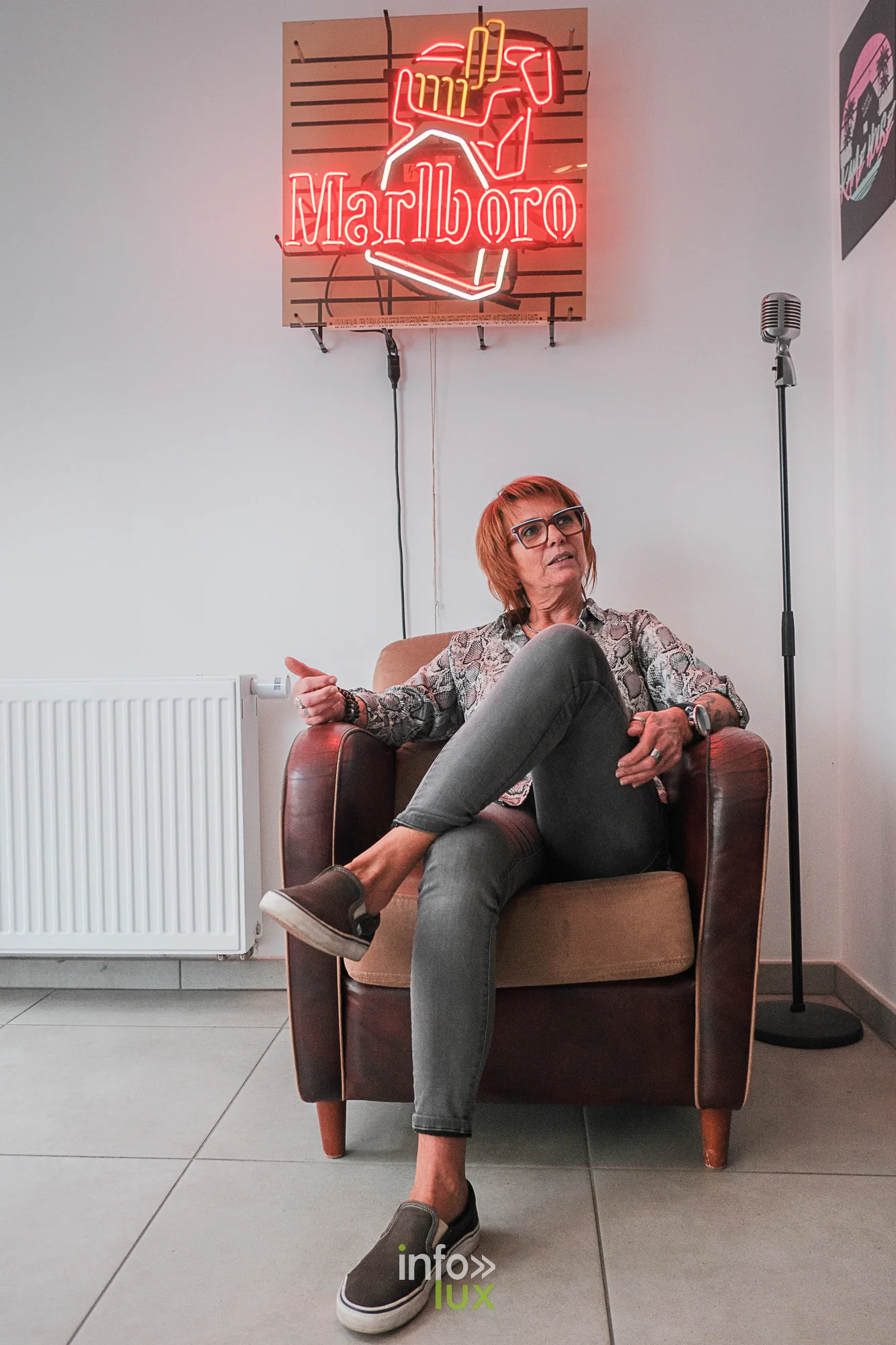 Ann Martin dans son salon de Neufchâteau, sous une enseigne au néon — Invitée BKS