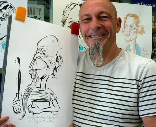Un dessinateur souriant présente une caricature à l’encre réalisée en direct