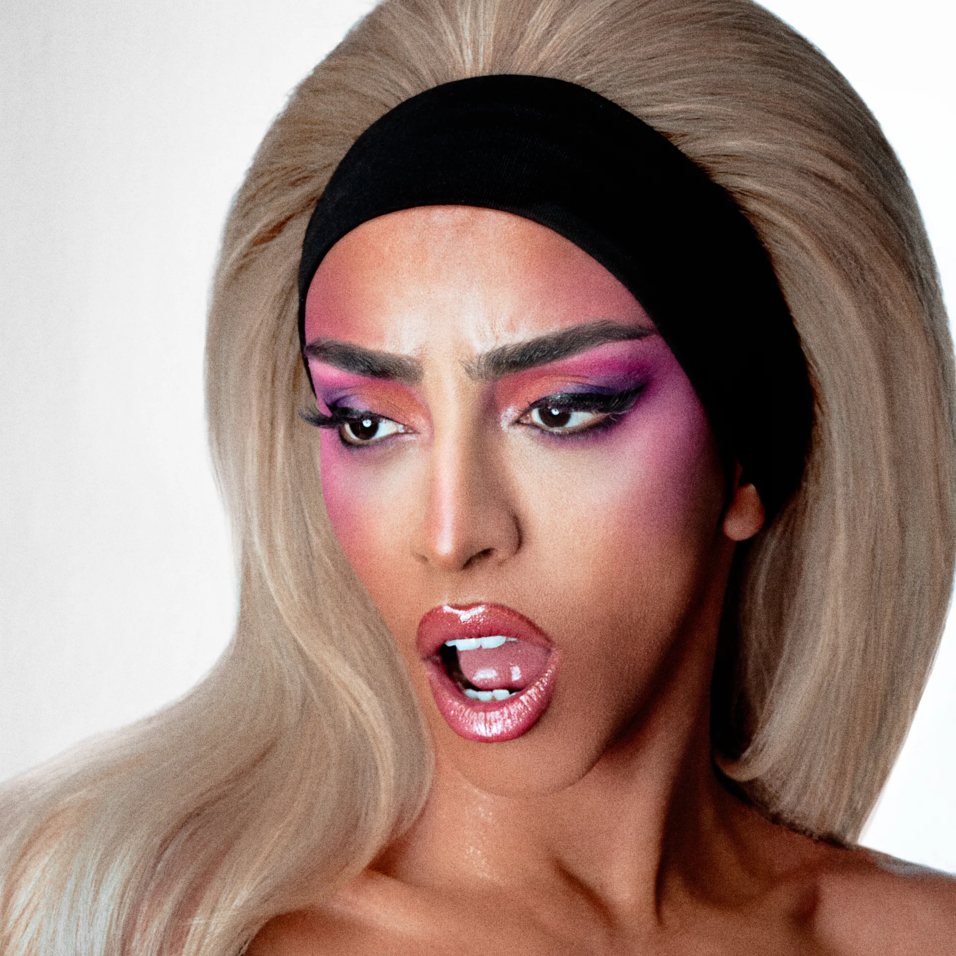 Portrait en gros plan de Bilal Hassani, maquillage rose et perruque blonde