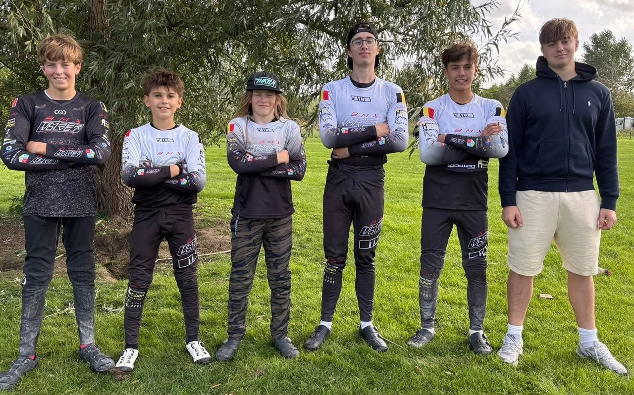 Le groupe des pilotes du BMX Timberwolves Racing Habay aligné devant les arbres à Wachtebeke