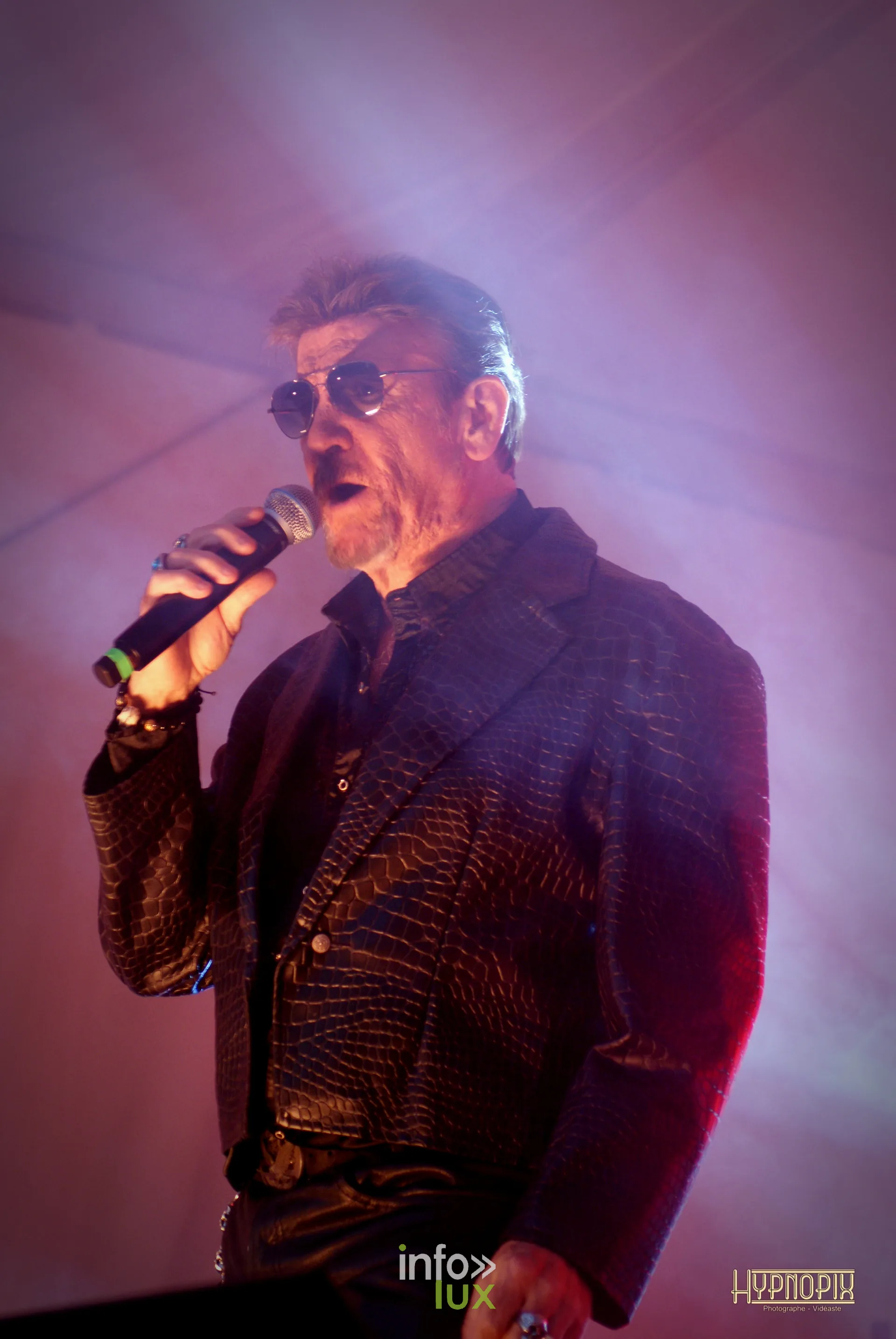Chanteur en veste et lunettes noires sur la scène de la Braderie de Braine-l’Alleud 2026