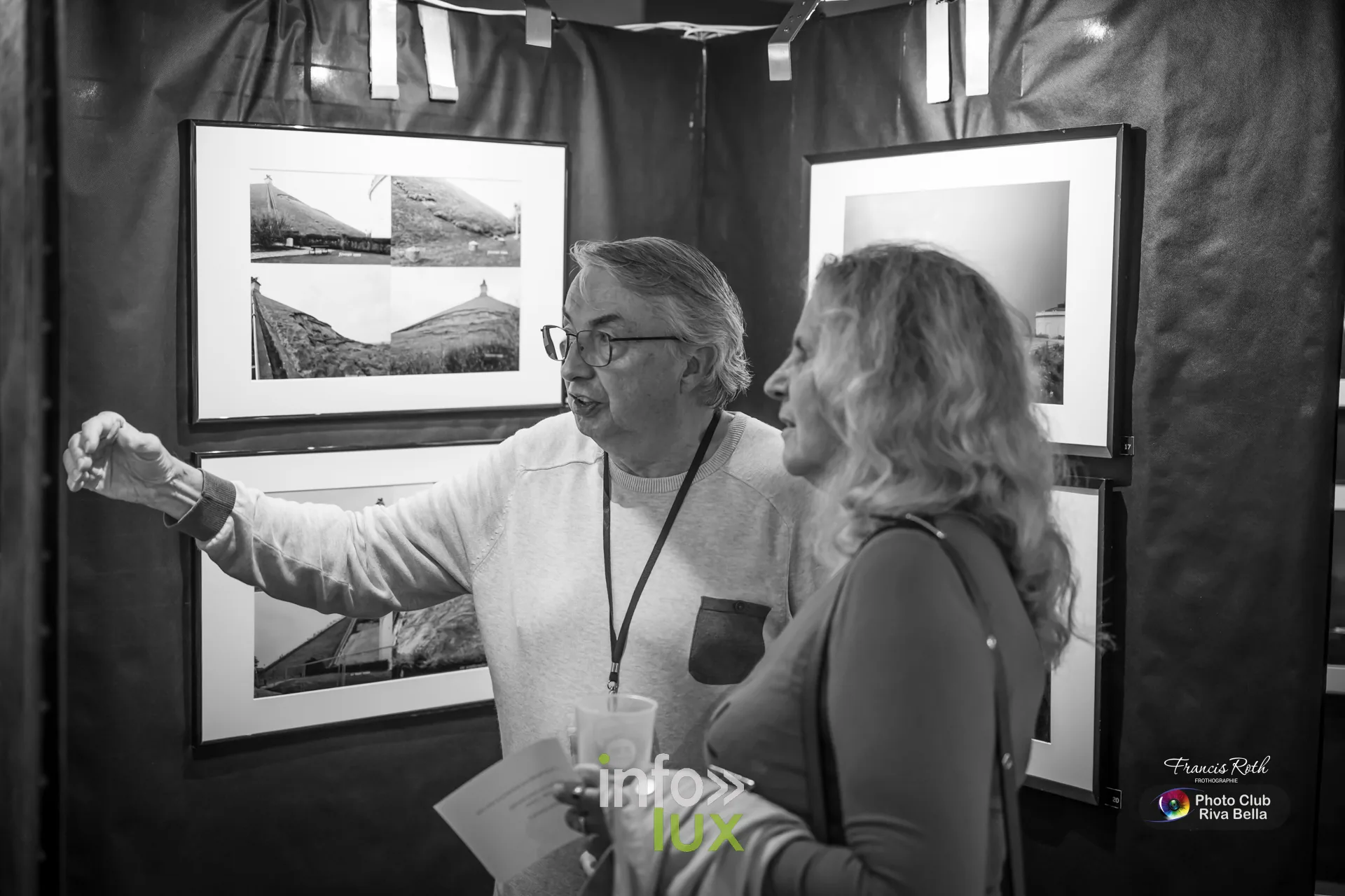 Photographe du Photo-Club Riva Bella commentant ses tirages devant des visiteurs au POP de Braine-l’Alleud