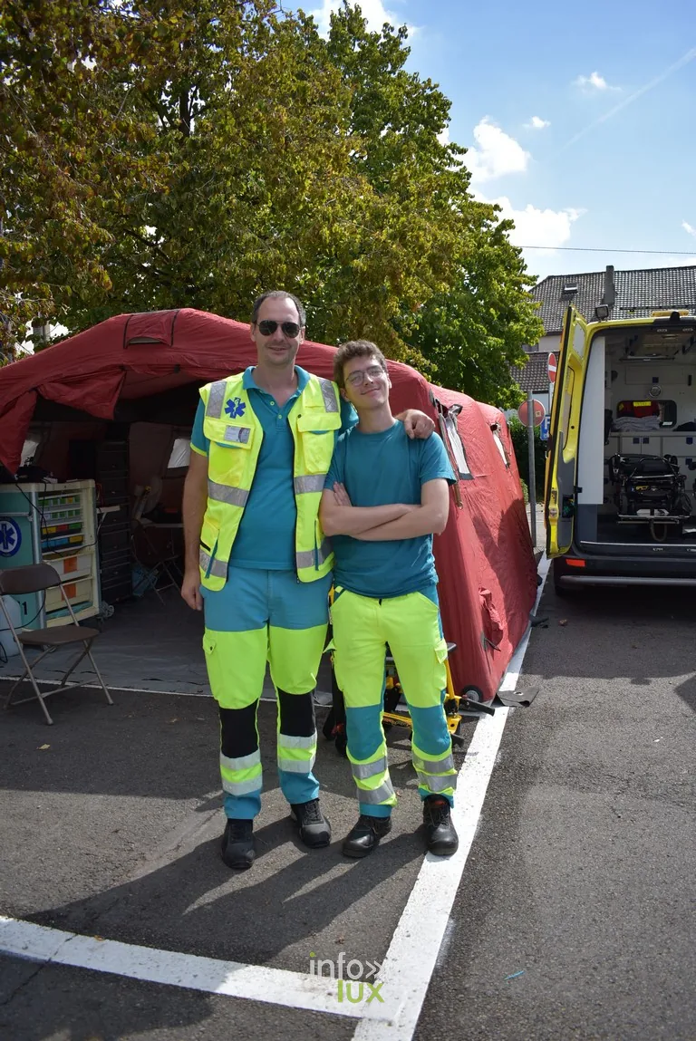 Deux secouristes en tenue devant leur ambulance pendant la braderie