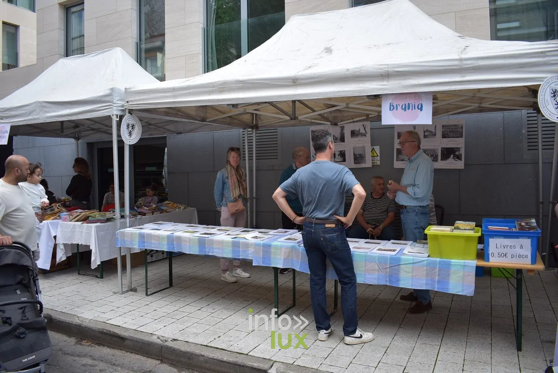 Un stand d'information tenu par des bénévoles sous chapiteau
