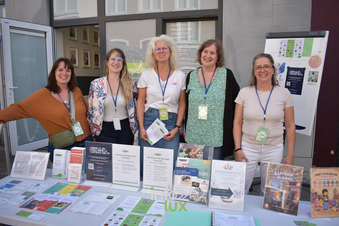 Cinq femmes posent derrière le stand d'une association