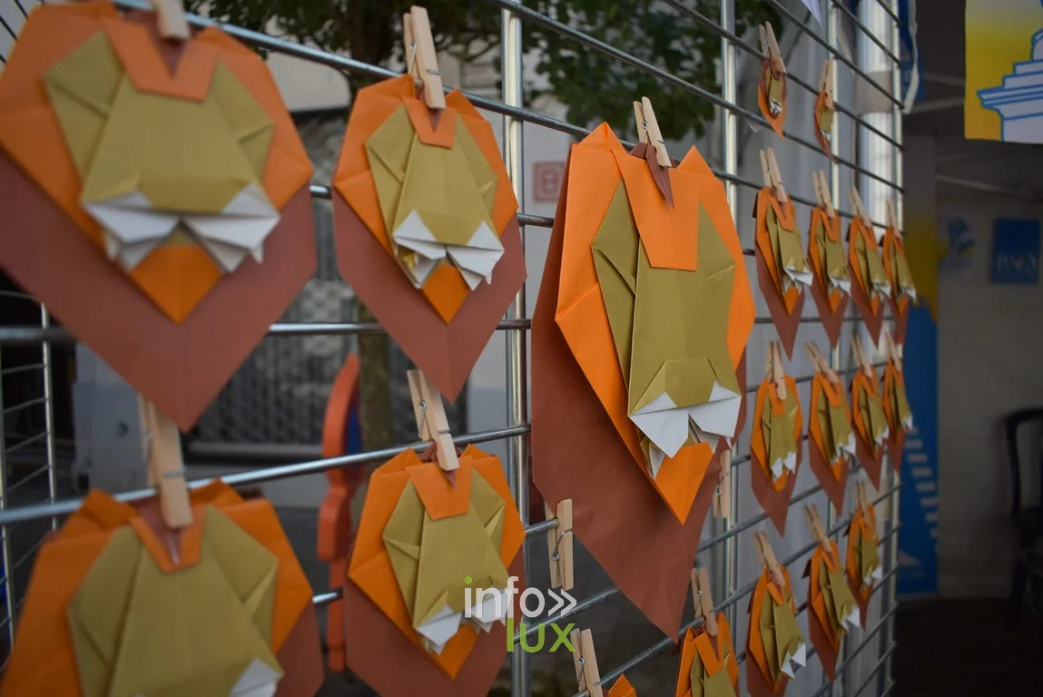 Des origamis colorés suspendus à un fil au-dessus d'un stand