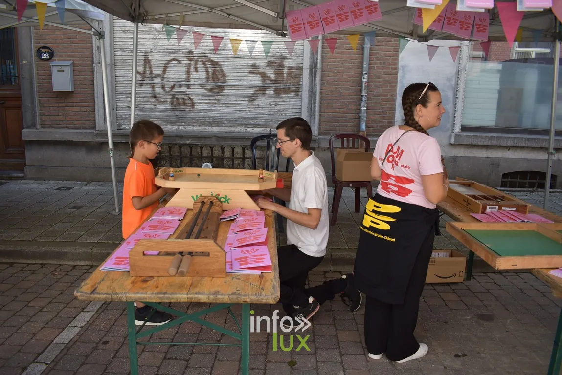 Des enfants et des adultes autour de tables d'atelier en bois