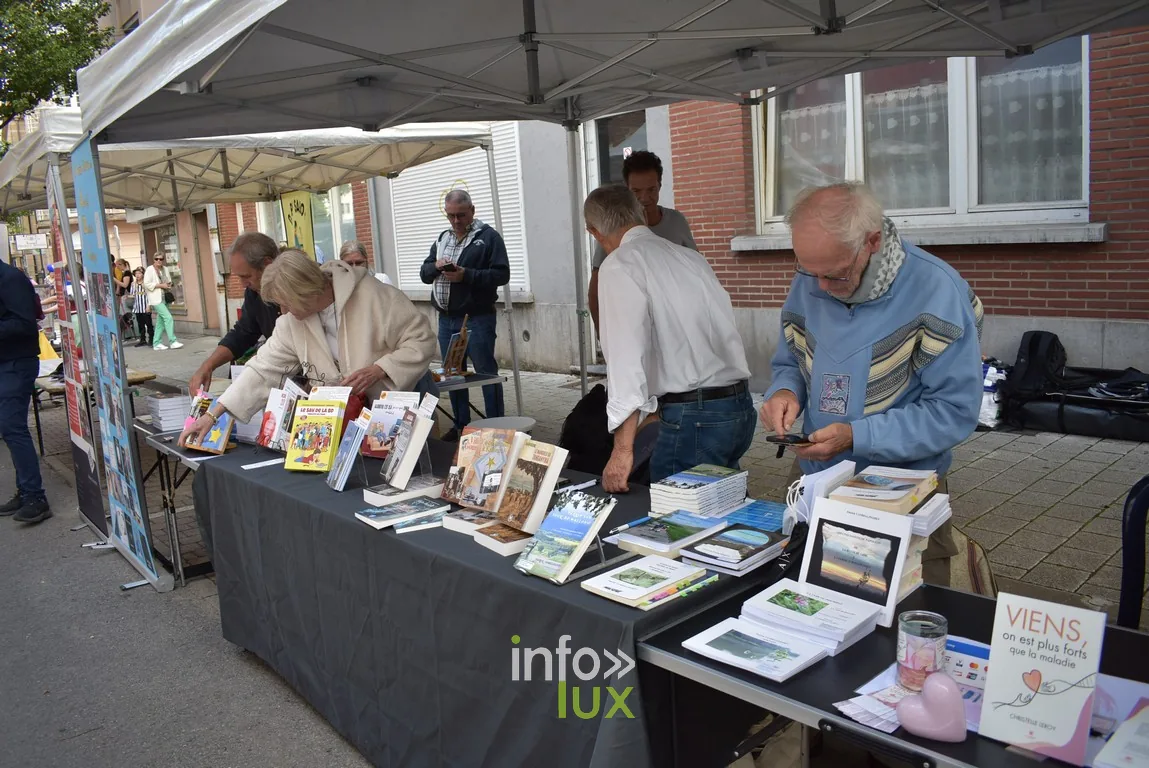 Des visiteurs consultent des livres sur un stand de bouquiniste