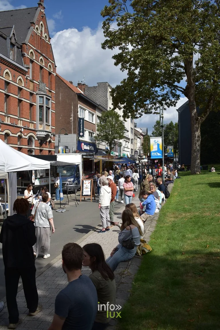 Des visiteurs assis sur la pelouse du parc pendant la braderie