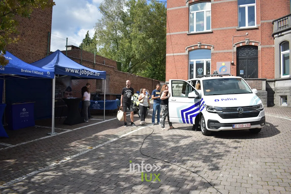 Des visiteurs et des stands au bout d'une rue pavée