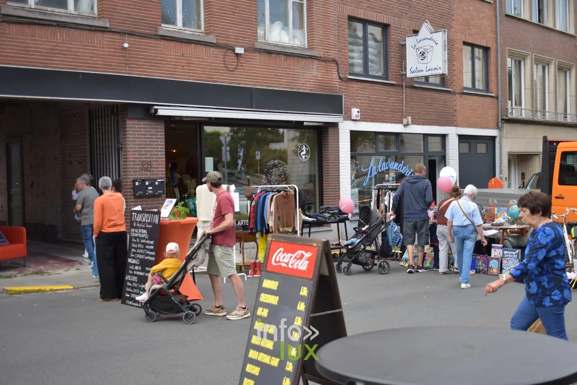 Des visiteurs devant les commerces d'une rue pendant la braderie