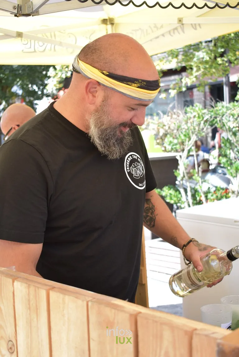Un tenancier sert une boisson derrière son comptoir en bois