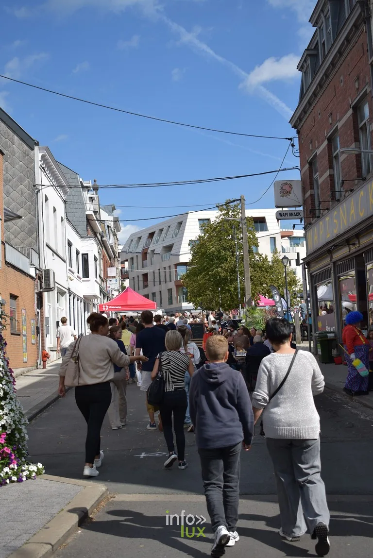 La foule remonte une rue de Braine-l'Alleud sous le soleil
