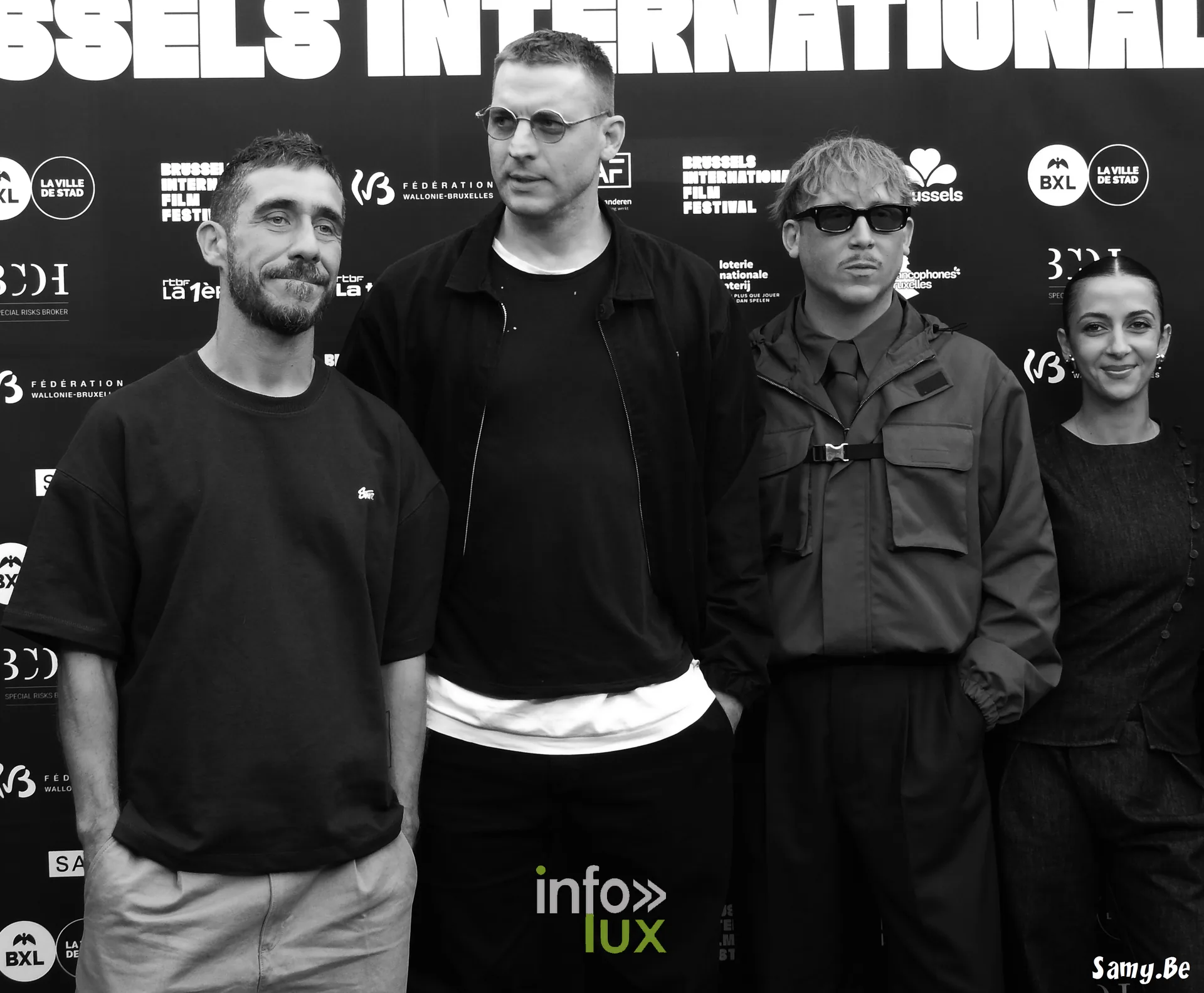 Quatre membres de l'équipe de Vigilante devant le mur du festival