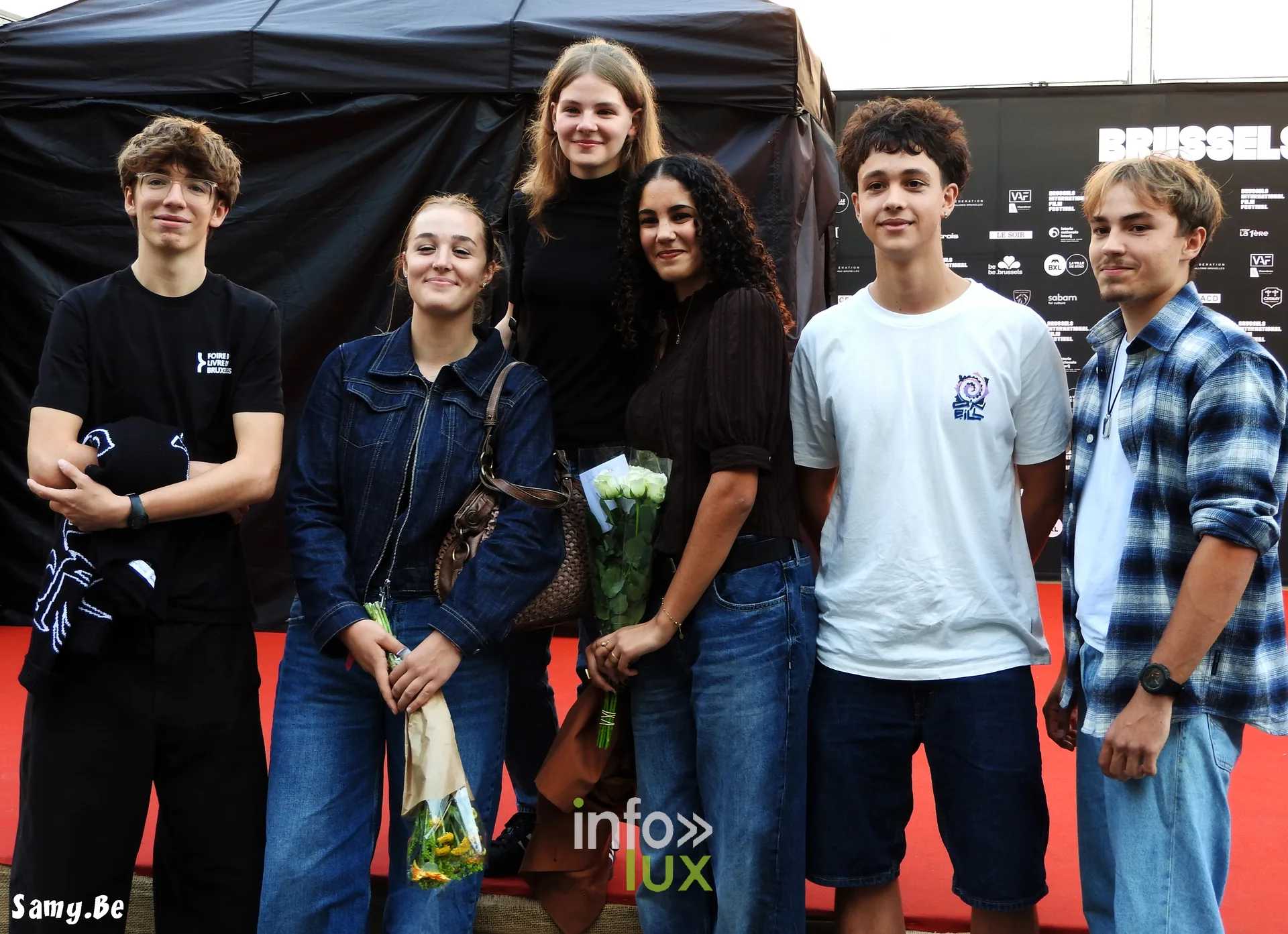 Des jeunes spectateurs et l'équipe de Vigilante avec des fleurs
