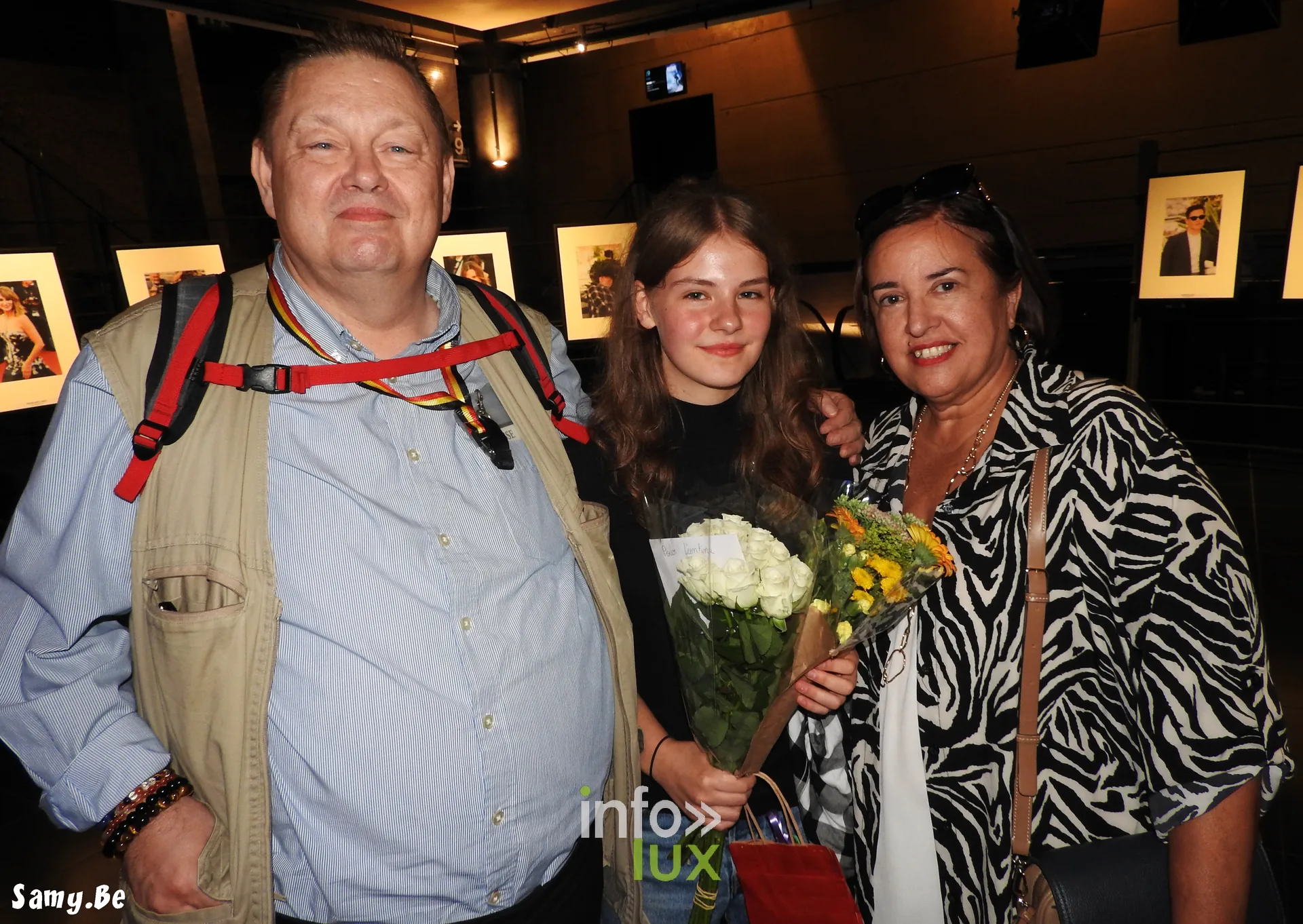 Trois invités posent avec un bouquet dans le hall du festival