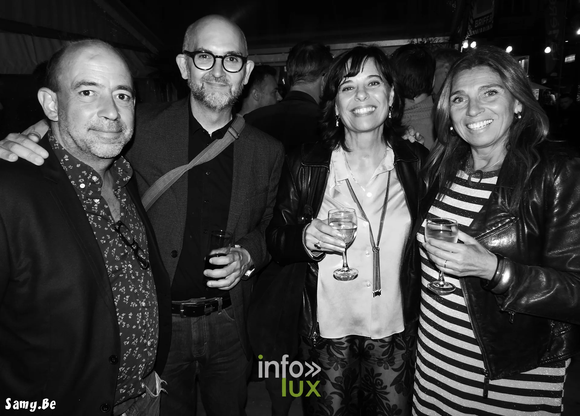 Quatre professionnels du cinéma en noir et blanc lors d'une soirée du festival