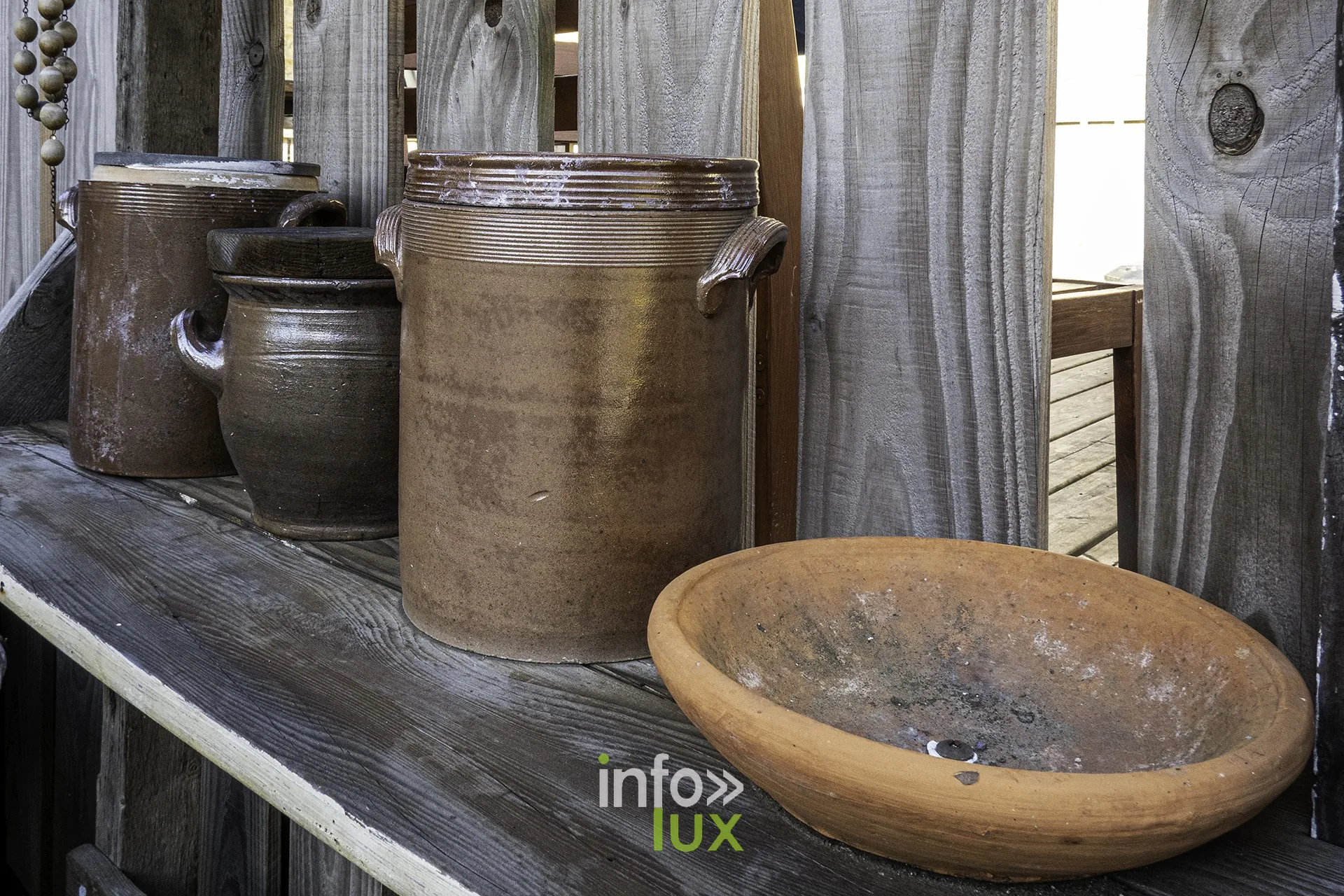 Pots en grès et jatte en terre cuite sur une étagère en bois, cour du château fort de Sedan
