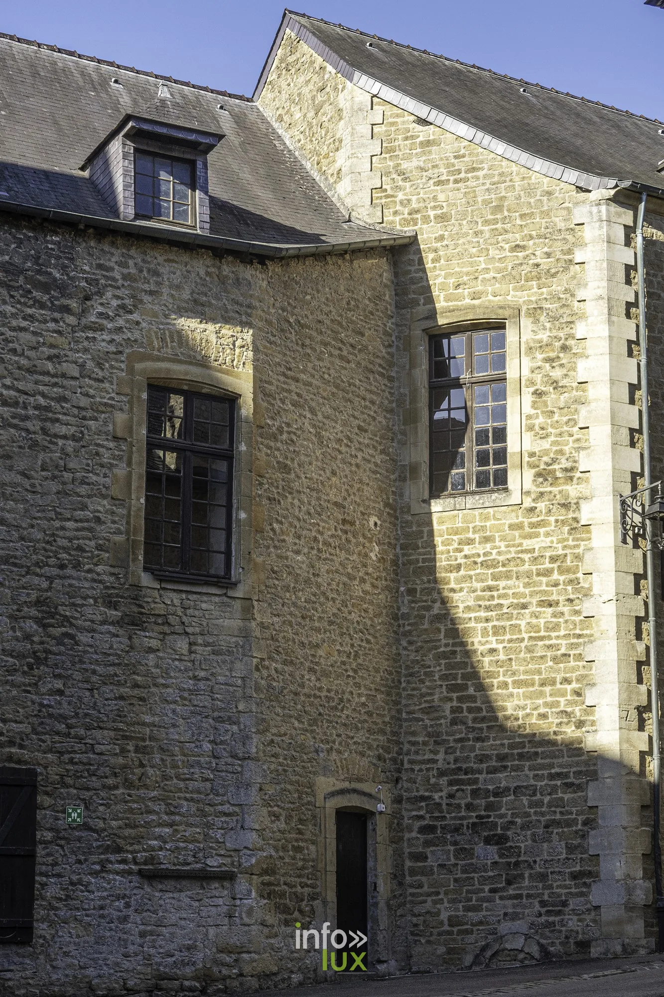 Façade en pierre avec fenêtres à meneaux dans la cour du château fort de Sedan