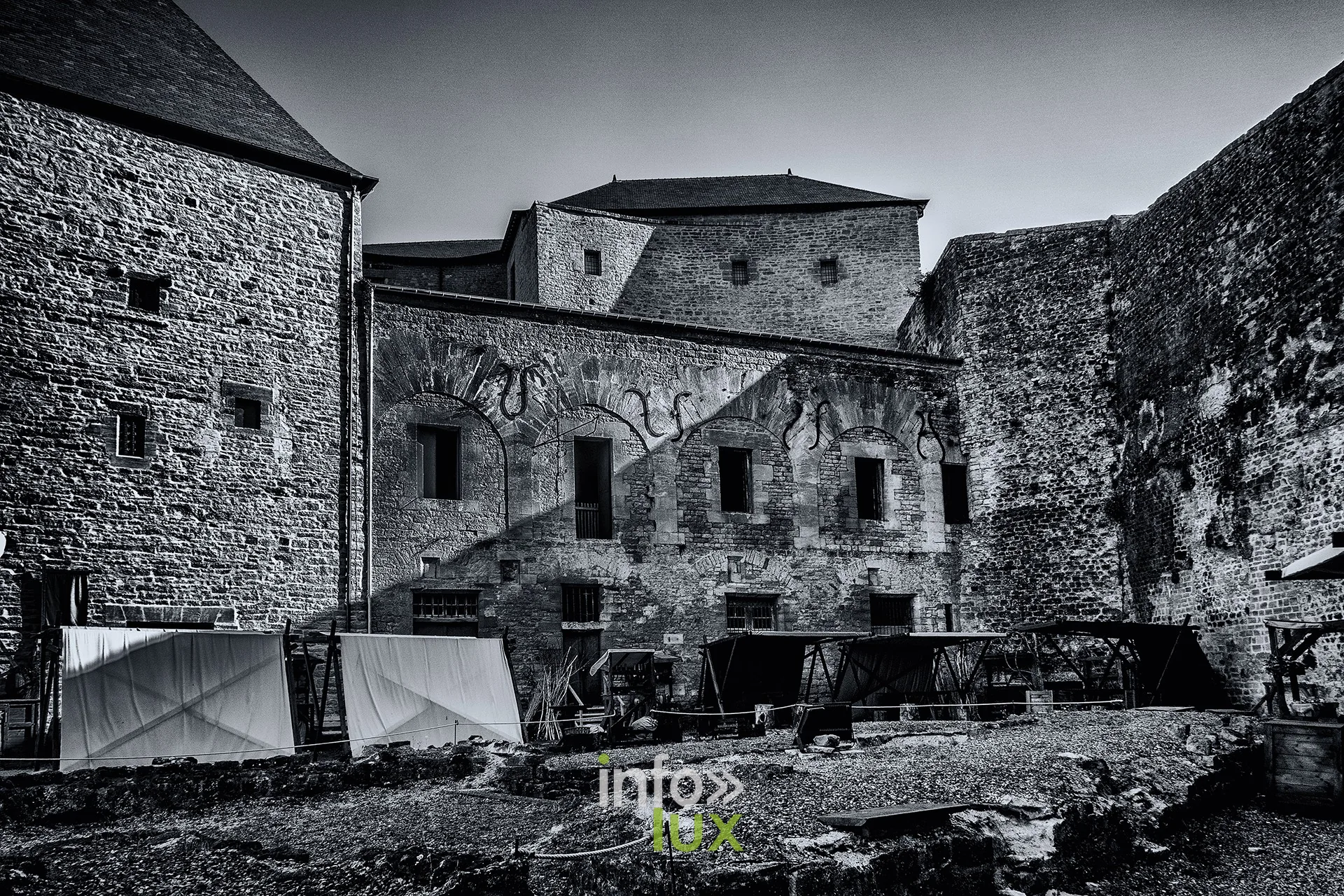 Cour intérieure du château fort de Sedan en noir et blanc, tentes blanches au premier plan