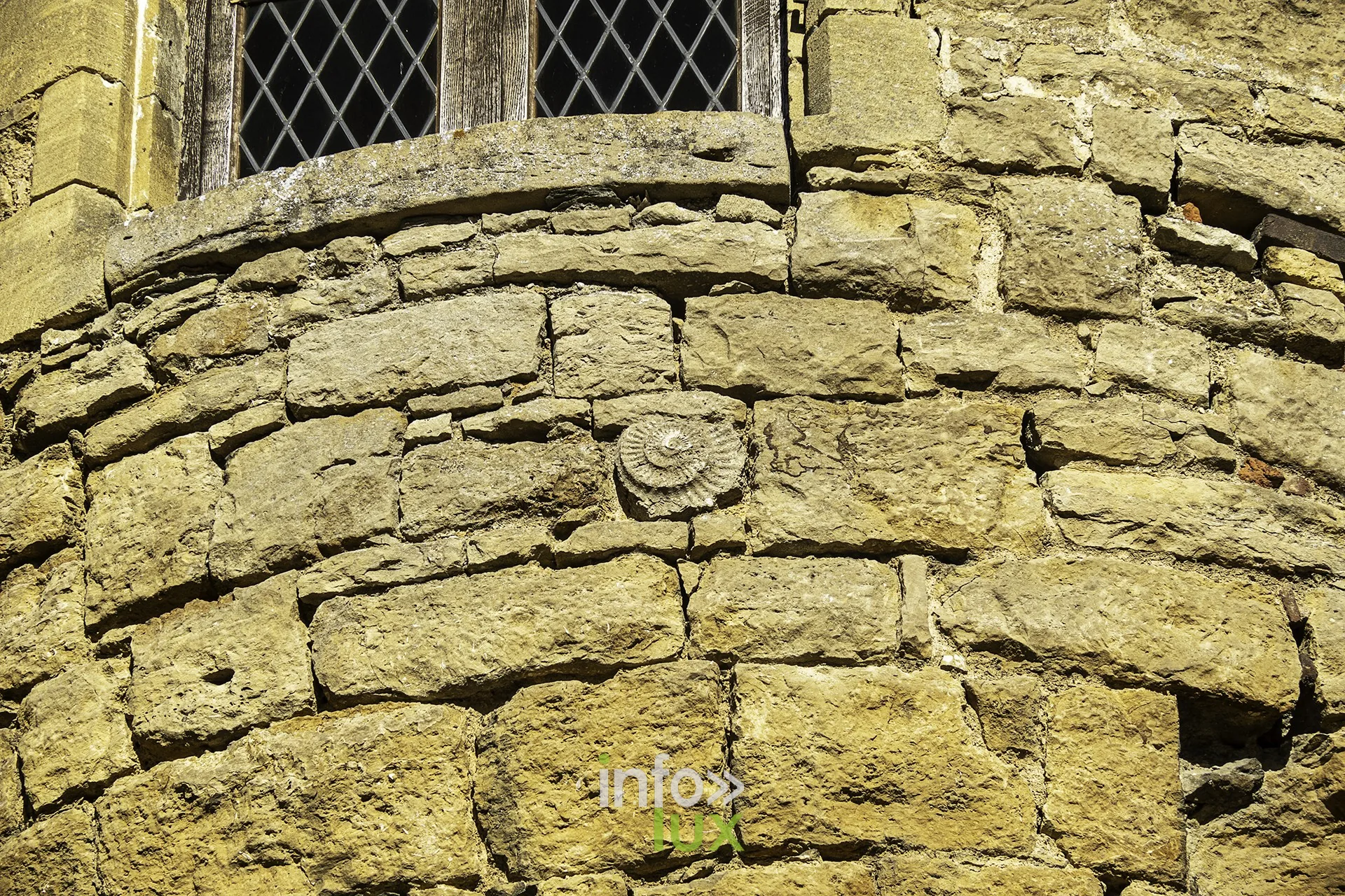 Détail de la maçonnerie d’une tour ronde avec rosace sculptée, château fort de Sedan