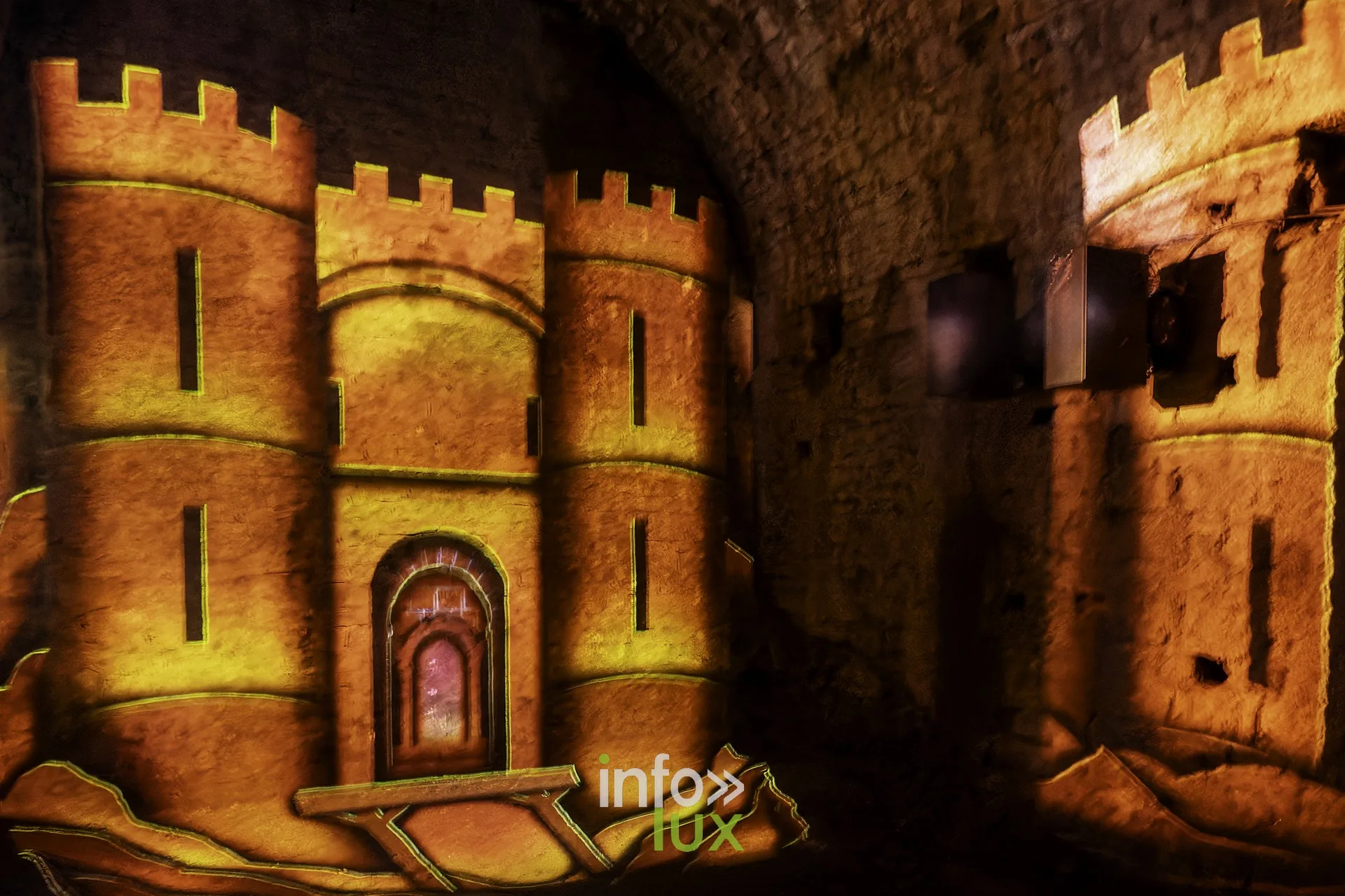 Projection lumineuse d’un château à tours sur les murs d’une salle voûtée au château fort de Sedan (Ardennes)
