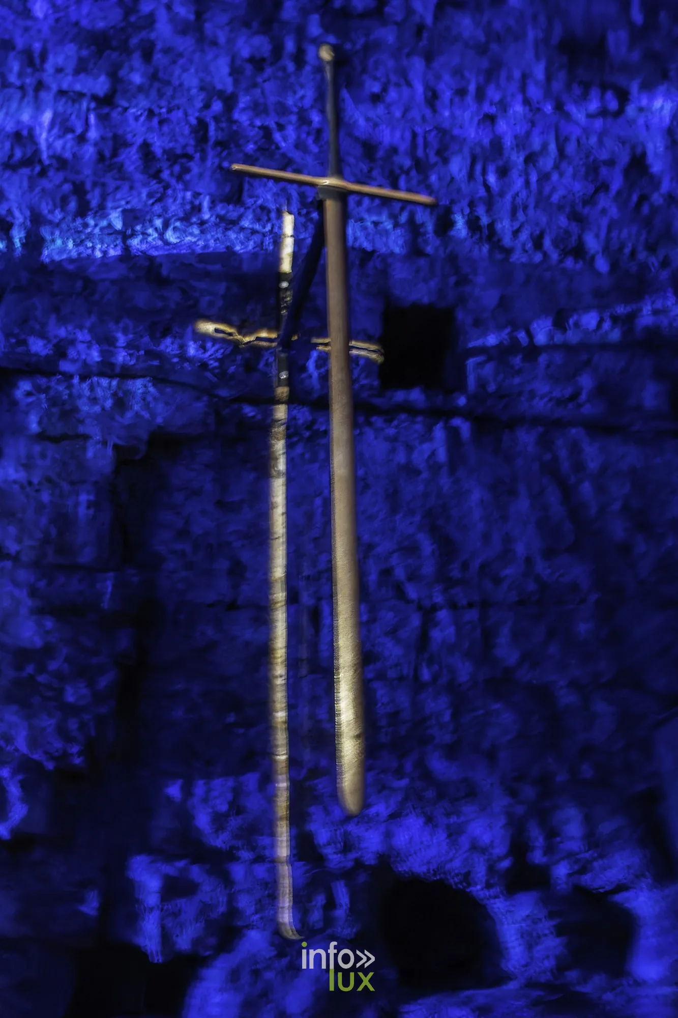 Épée suspendue devant un mur éclairé en bleu au château fort de Sedan (Ardennes)