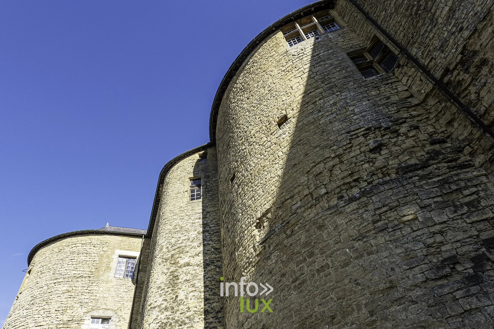 Tours rondes massives du château fort de Sedan en contre-plongée sous un ciel bleu