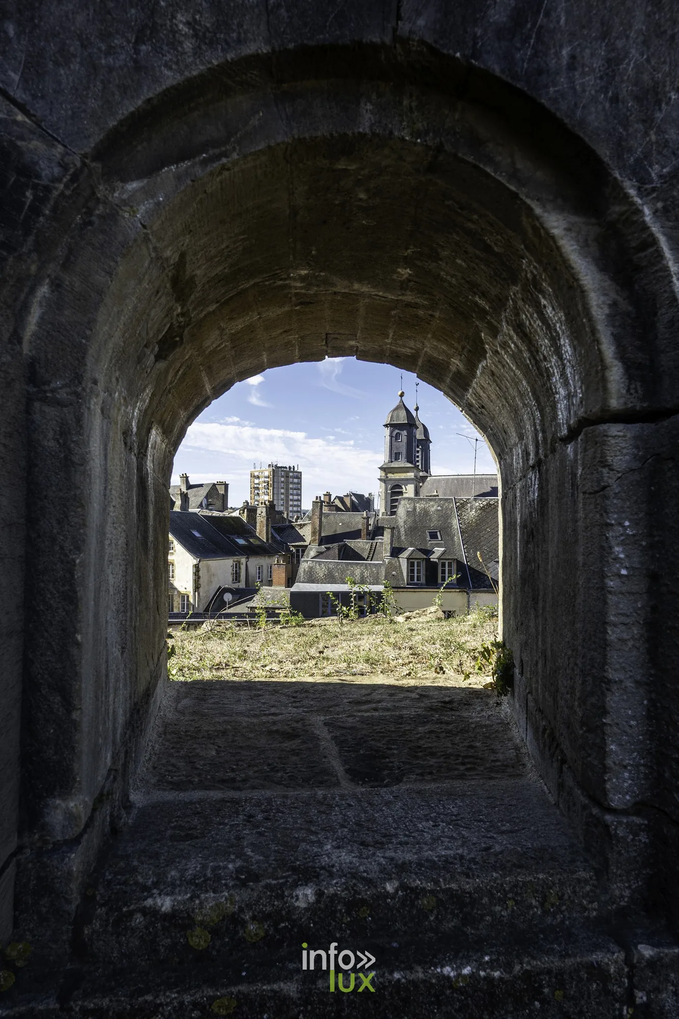 Passage voûté dans le rempart ouvrant sur les toits de Sedan et un clocher