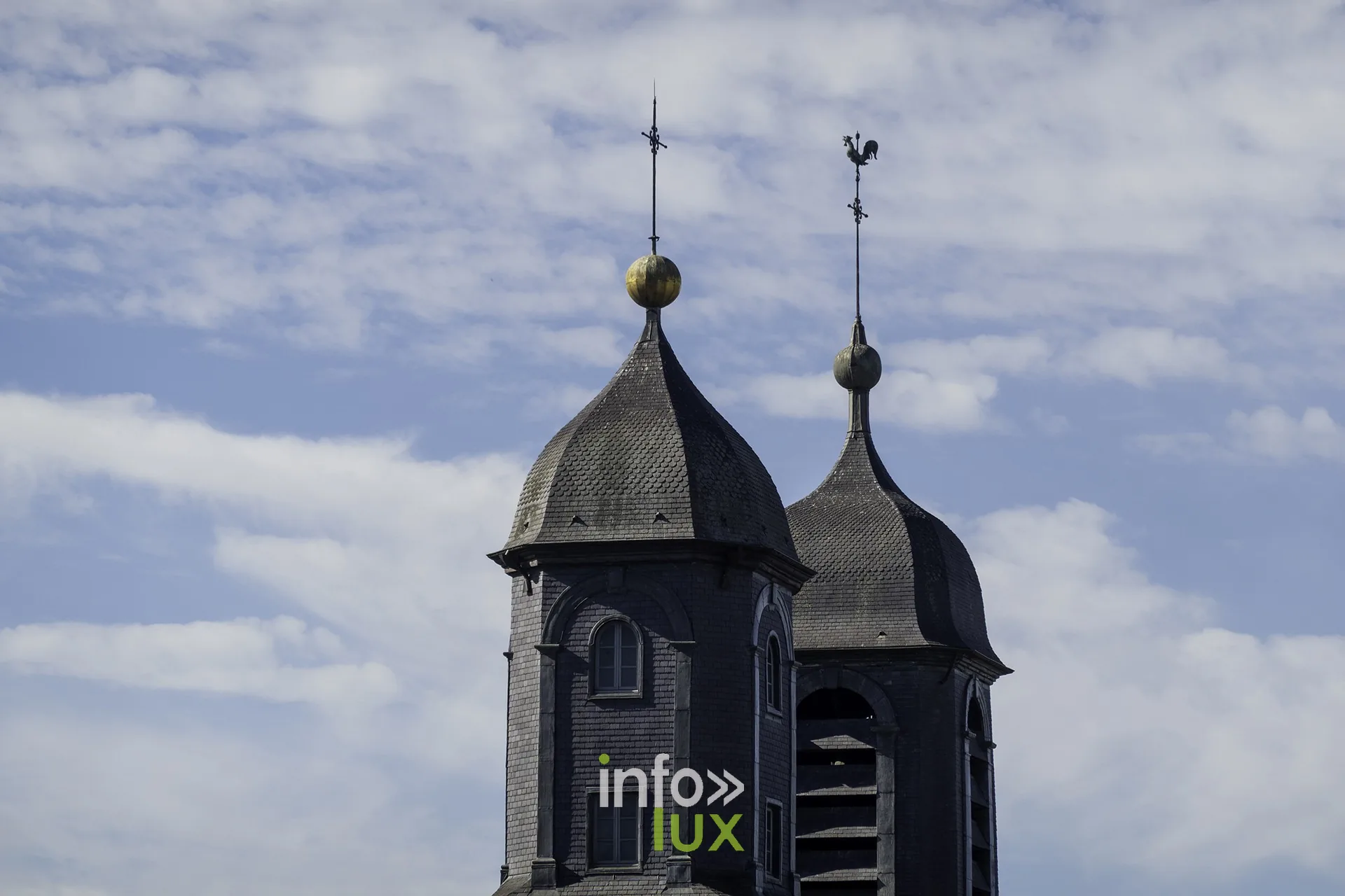 Les deux clochers à bulbe de l’église Saint-Charles-Borromée de Sedan sous un ciel nuageux