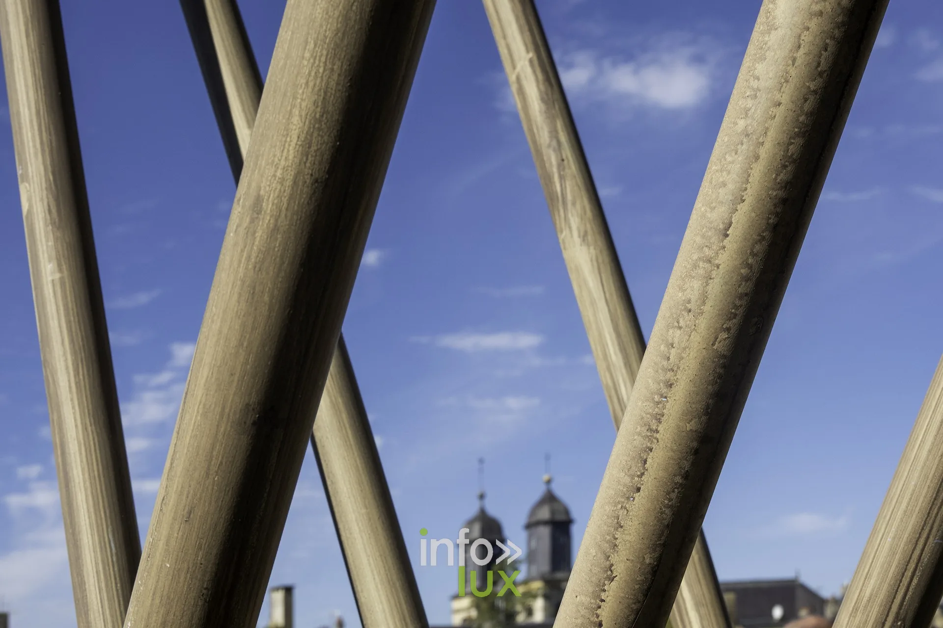 Pieux de bois croisés devant les clochers de Sedan, sur le site du château fort
