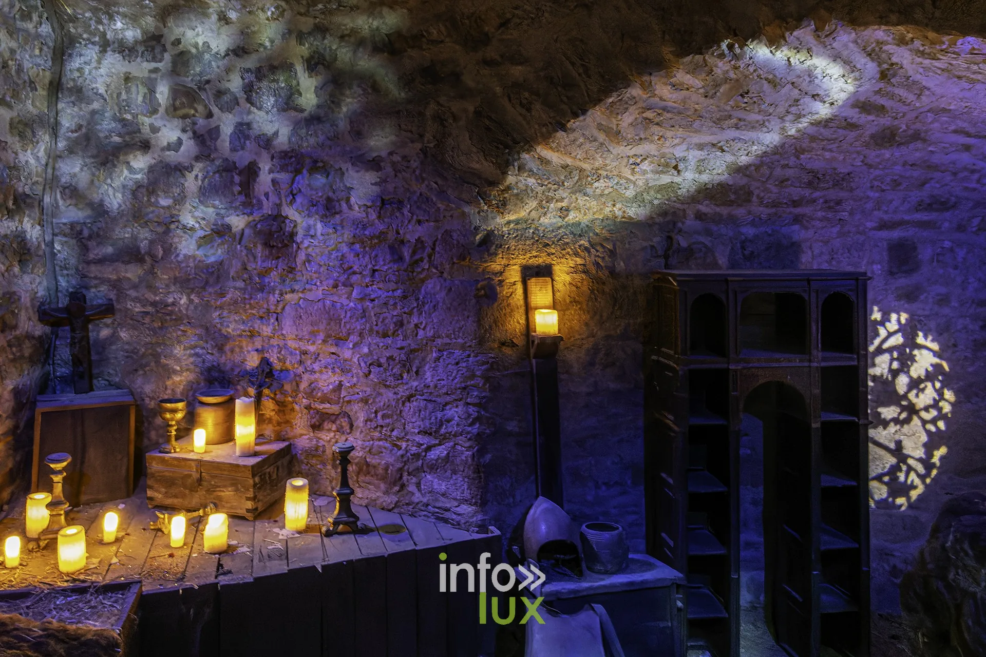 Salle voûtée mise en scène avec bougies, casque et étagères au château fort de Sedan (Ardennes)