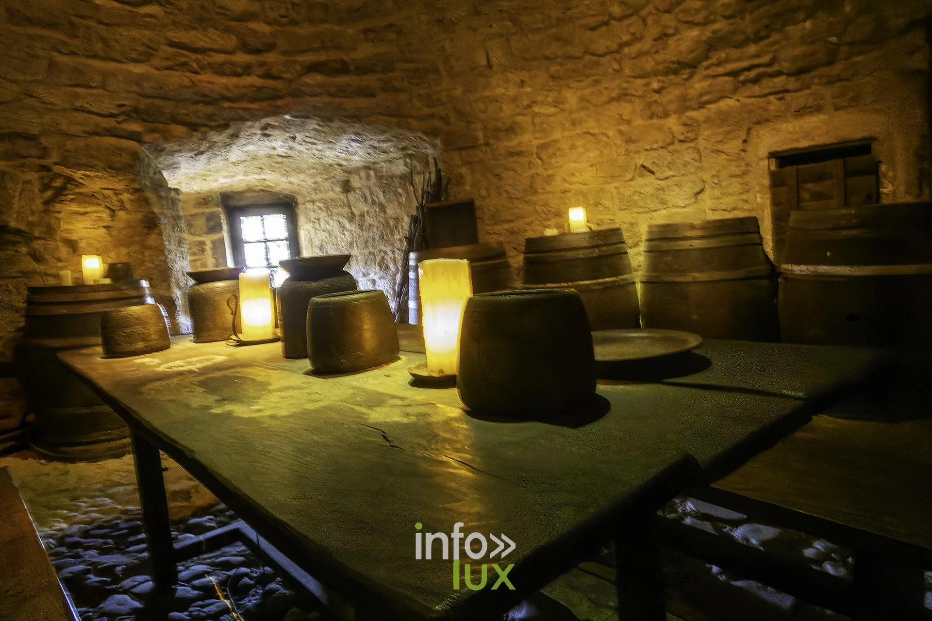 Cellier voûté avec tonneaux et table éclairée à la bougie au château fort de Sedan (Ardennes)