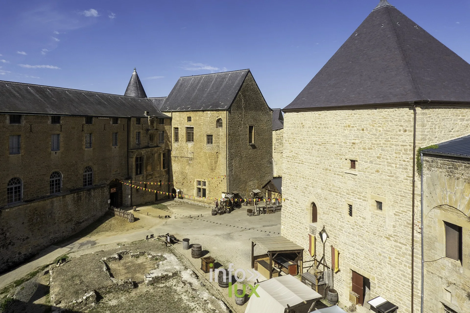 Vue plongeante sur la cour intérieure du château fort de Sedan avec tentes et tonneaux