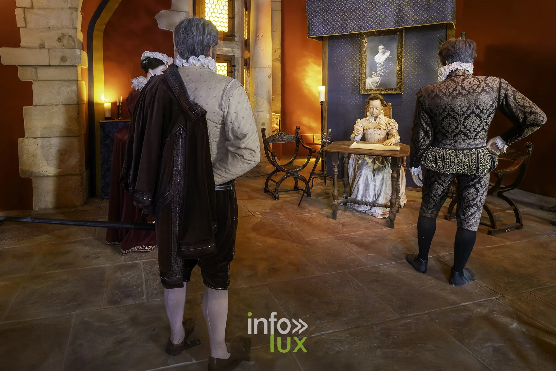 Scène reconstituée : personnages en costumes du XVIe-XVIIe siècle autour d’une femme assise à un bureau, au château fort de Sedan (Ardennes)
