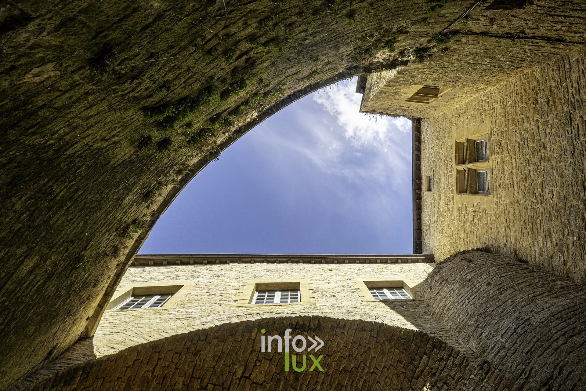 Voûte encadrant le ciel et une façade du château fort de Sedan